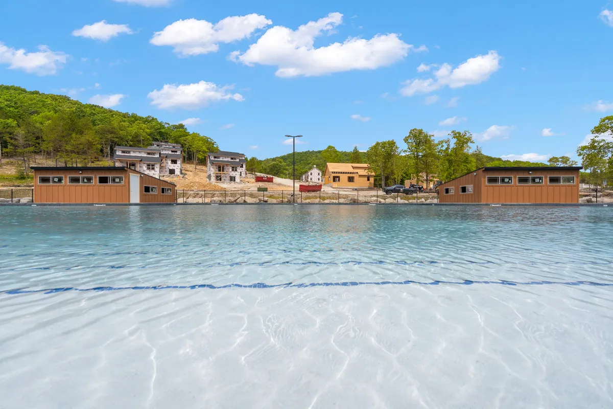 A tranquil lakeside setting featuring calm water, cozy cabins nestled among lush trees, and a serene atmosphere perfect for boating or relaxing by the shore. The natural scenery conveys the outdoor adventure and water recreation opportunities nearby.